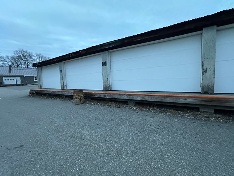 Close view of multi-bay commercial storage doors with raised loading dock — MA
